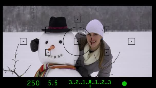 Taking photos of a girl with a snowman — Stock Video
