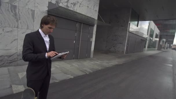 Jeune homme d'affaires avec skateboard — Video