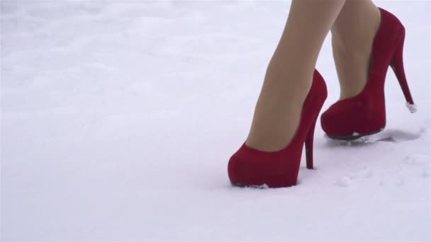 Donna con i tacchi alti che cammina sulla neve — Video Stock