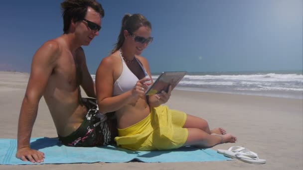 Couple sur la plage en utilisant une tablette numérique — Video