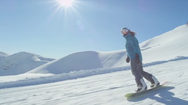 Girl snowboarding on sunny day — Stock Video