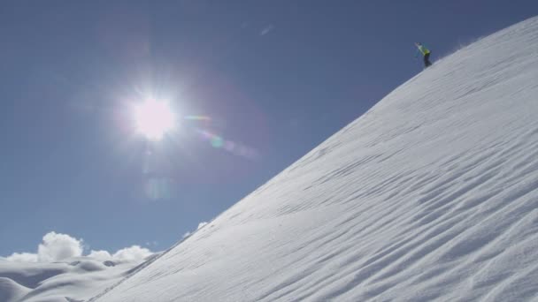 Snowboarder sprays verse sneeuw — Stockvideo