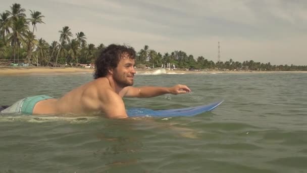 Surfer paddelt hinaus — Stockvideo