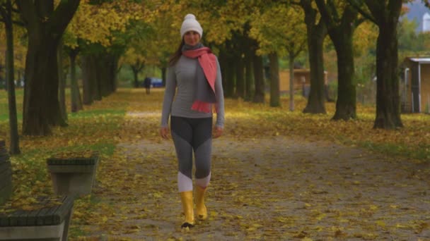 RETRATO: Mulher branca sorridente passeia ao longo de um passeio colorido de outono. — Vídeo de Stock