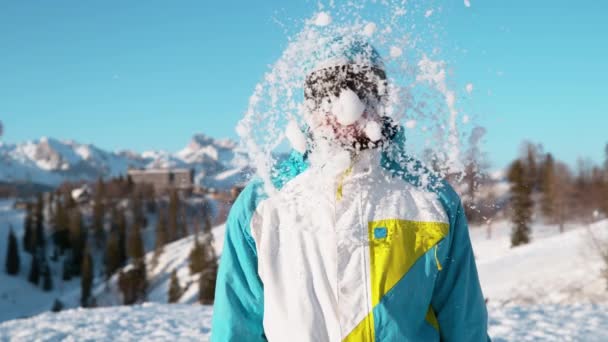 CERRAR: Hombre surtido snowboarder recibe un golpe en la cabeza por una gran bola de nieve húmeda. — Vídeo de stock