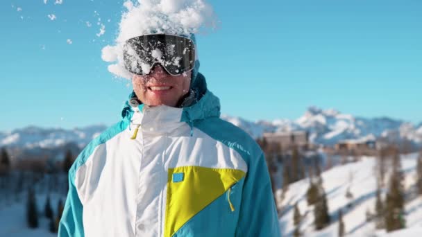 Nah dran: Lächelnder Mann im Aktivurlaub in den Alpen gerät in Schneekampf. — Stockvideo