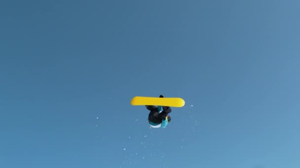 MOVIMIENTO Lento: Tiro de un snowboarder macho saltando del pateador y haciendo un truco. — Vídeos de Stock