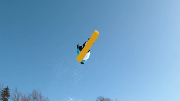 SLOW MOTION: Mannelijk toeristisch snowboarden in Slovenië doet een spectaculaire backflip. — Stockvideo