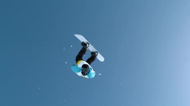 MOCIÓN LENTA: Snowboarder hace un backflip después de saltar de un pateador masivo. — Vídeos de Stock