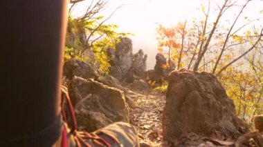 Atletik bayan yürüyüşçü güneşli bir dağda manzaralı bir yolda yürüyor..