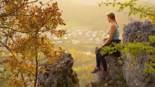 COPY SPACE: Młoda kobieta wędrowiec siedzi na dużej skale i obserwuje dolinę. — Wideo stockowe