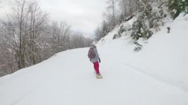 Ormandan geçen kayak merkezi yamacında tanınmayan kadın snowboard yapıyor..