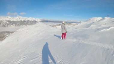 Kadın snowboardcu pistte giderken taze toz karını parçaladı..