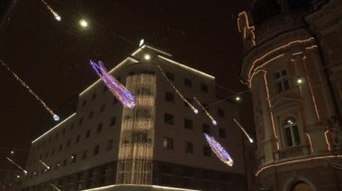 Galaksi ve yıldız yılbaşı ışıkları karanlık şehir caddesini aydınlatıyor..