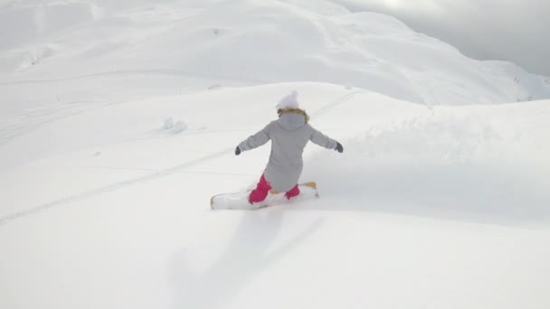 SLOW MOTION: Vrouw snowboards cross country en snippers vers poeder sneeuw. — Stockvideo