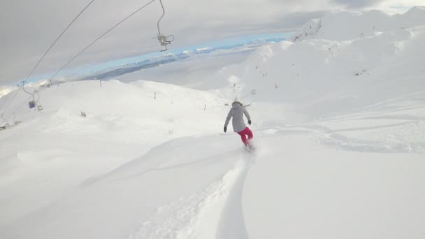 SLOW MOTION: Μη αναγνωρίσιμος snowboarder βόλτες εκτός πίστας σε μια τέλεια χειμωνιάτικη μέρα. — Αρχείο Βίντεο