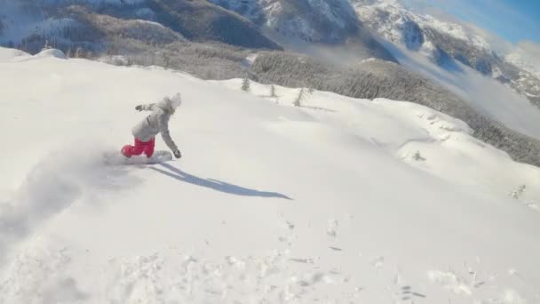 スローモーション:バックカントリーでのアクティブな冬の休暇のスノーボードの女性. — ストック動画