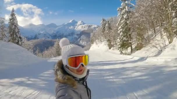 SELFIE: Жіночі сноубордистські круїзи по доглянутому схилу в сонячний зимовий день . — стокове відео