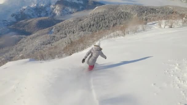 SLOW MOTION: Extreme female rider snowboards in the backcountry of Julian Alps. — Stockvideo