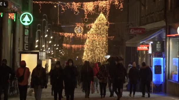 People wearing masks explore the idyllic city streets of Ljubljana in December — Stockvideo