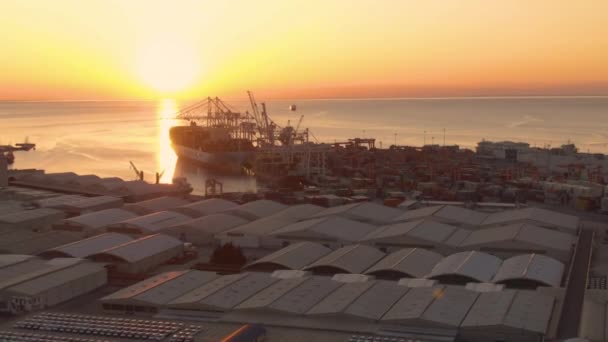 Matahari terbenam bersinar di derek dan kapal kargo yang sedang berlayar menuju pelabuhan.. — Stok Video