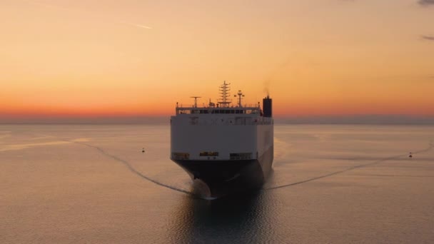 AERIAL: Drone shot de um navio transportador de mercadorias que transporta mercadorias ao pôr-do-sol. — Vídeo de Stock