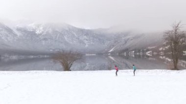 Bohinj Gölü yakınlarında kayak antrenmanı yapan bayan sporcular arasında uçuyorum..