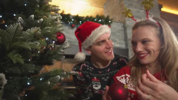 SLOW MOTION: Liefdevol jong stel versiert kerstboom in hun huis — Stockvideo