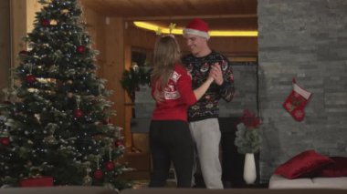 Sevecen çift Noel tatilini kutlarken mutlu bir şekilde dans ediyor.