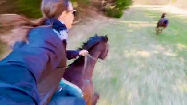 SELFIE: Female horseback rider speeds across a pasture with her athletic horses. — 图库视频影像