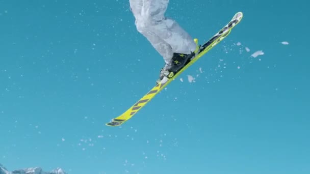 CLOSE UP Action shot of freestyle skier taking off a kicker and doing a 360 grab — стоковое видео