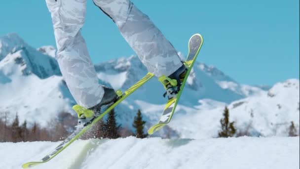 CLOSE UP: Cinematische opname van de uitrusting van een skiër als hij vertrekt een grote kicker. — Stockvideo