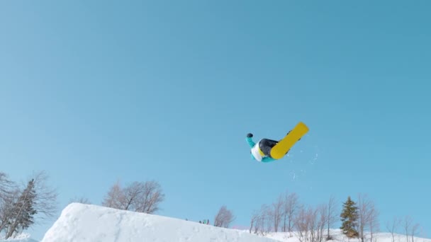 BOTTOM UP: Spectacular shot of a snowboarding pro doing a tumbling grab stunt. — Stock Video