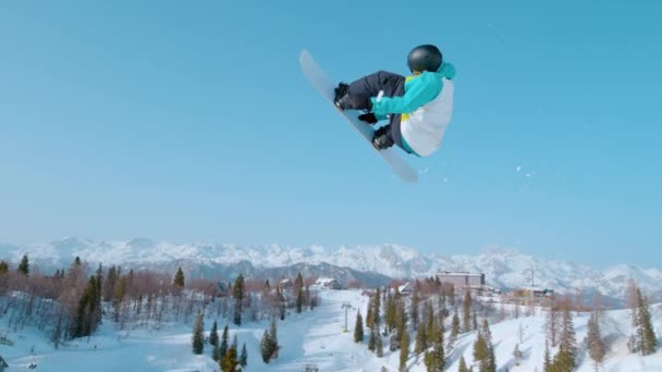 MOCIÓN LENTA: Snowboarder se eleva por el aire y hace un truco impresionante. — Vídeos de Stock