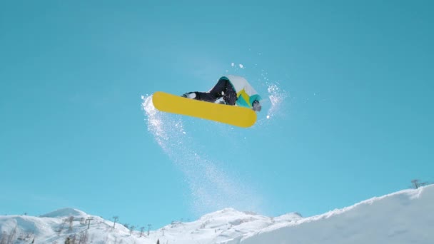 BOTTOM UP: Athletic male tourist snowboarding in Alps does a spinning trick — Vídeo de Stock