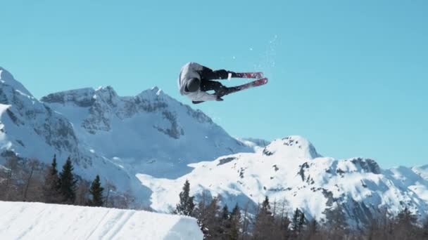 TIME WARP: Toma de acción de un esquiador freestyle despegando y haciendo una toma de 360. — Vídeos de Stock