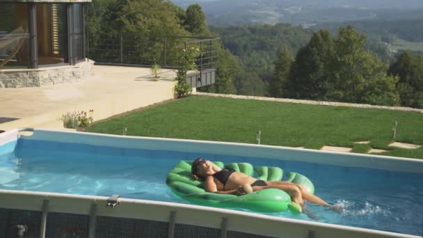 Carefree Kavkazská žena leží na list floatie při relaxaci ve svém domácím bazénu. — Stock video