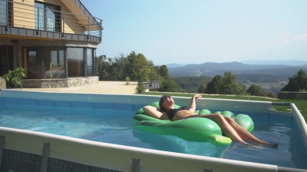 COPY SPACE: Junge Frau, die sich im Pool räkelt, bekommt ihr Essen von einer Drohne geliefert. — Stockvideo