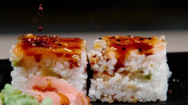 Açık kahverengi soya sosu geleneksel Japon suşisinin parçalarına sıçrar..