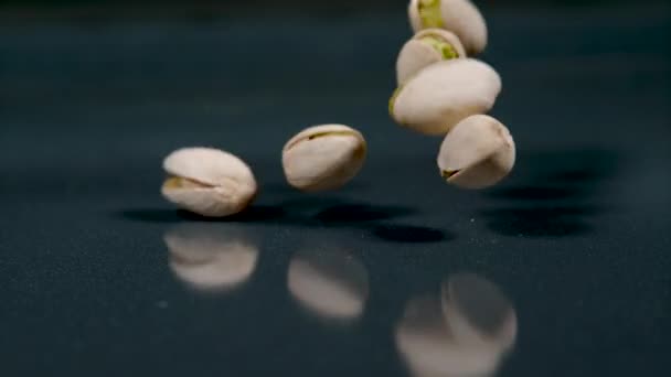 MACRO: Detailní záběr pistáciových ořechů padajících a poskakujících kolem pultu. — Stock video