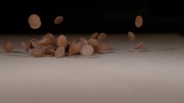 MACRO: Sabrosas gotas de chocolate con leche se dispersan por la mesa de comedor. — Vídeos de Stock