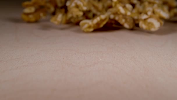 MACRO: Dried walnut halves glide along the wooden surface of a packaging machine — Stockvideo