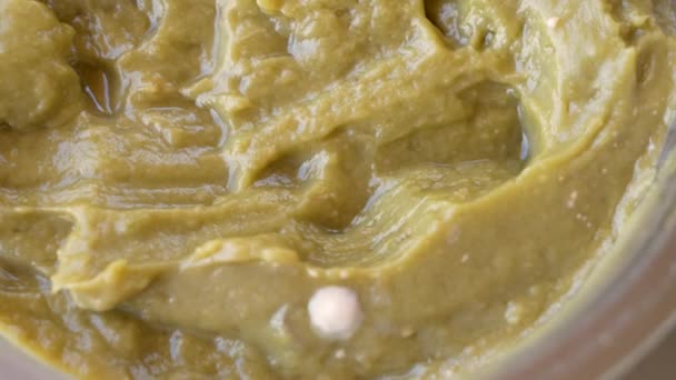 MACRO: Spores of mold spread across the surface of a jar of a hummus spread. — Stock Video