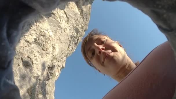 BOTTOM UP:若い女性は登山ルートを観察しながら彼女の指をチョーク. — ストック動画