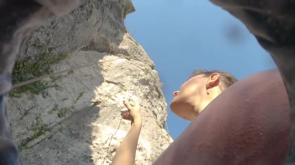 BOTTOM UP: Bergsteigerin analysiert Felswand beim Klettern in Slowenien. — Stockvideo