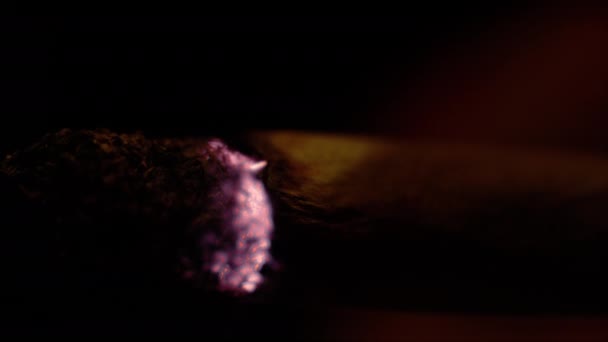 MACRO: Szczegółowe ujęcie płonącego jointa osoby palącej zioło w nocy. — Wideo stockowe