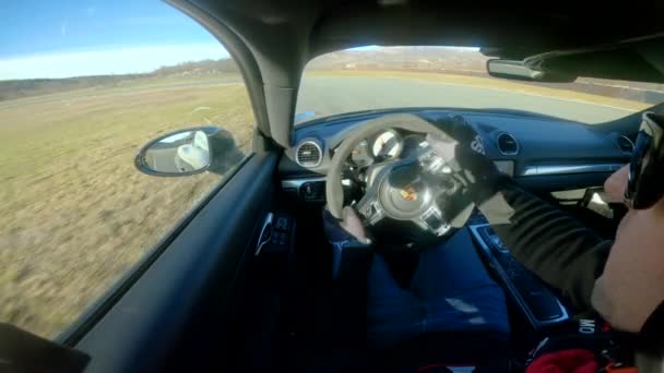 CLOSE UP: водитель гоночного автомобиля ездит на Porsche по пустой трассе. — стоковое видео