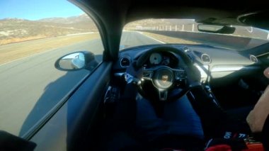 Genç adam Porsche 'sini boş pistin etrafında yarıştırıyor..