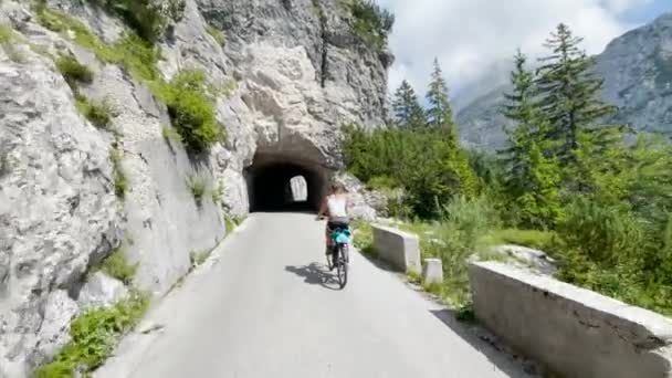 Jeune femme active sur un vélo de montagne pittoresque pédales vers un tunnel sombre. — Video