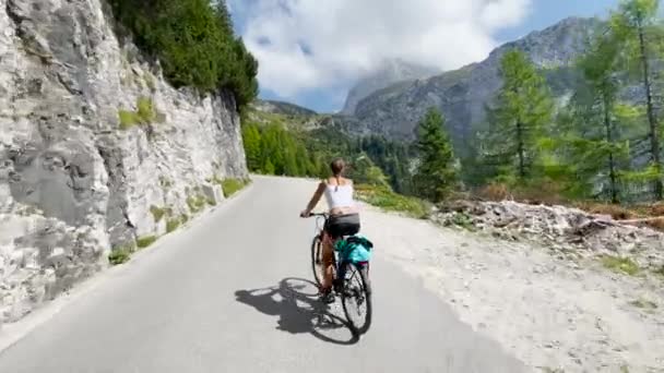 Scena panoramica di una turista in forma in sella ad una bicicletta su una strada che domina Mangart. — Video Stock